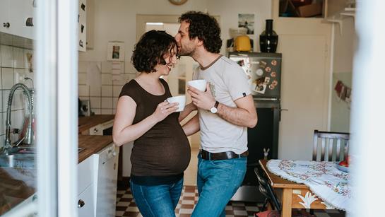 Pregnant Couple Drinking Tea In The Kitchen