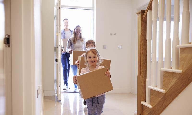 Young Family Moving In Children With Boxes