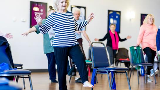 Older Woman Doing A Low Intensity Exercise Class With Other People