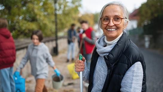 Older Woman Helping To Clean Up Communtiy
