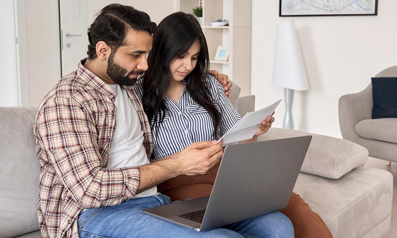 Couple On Laptop Looking At Form