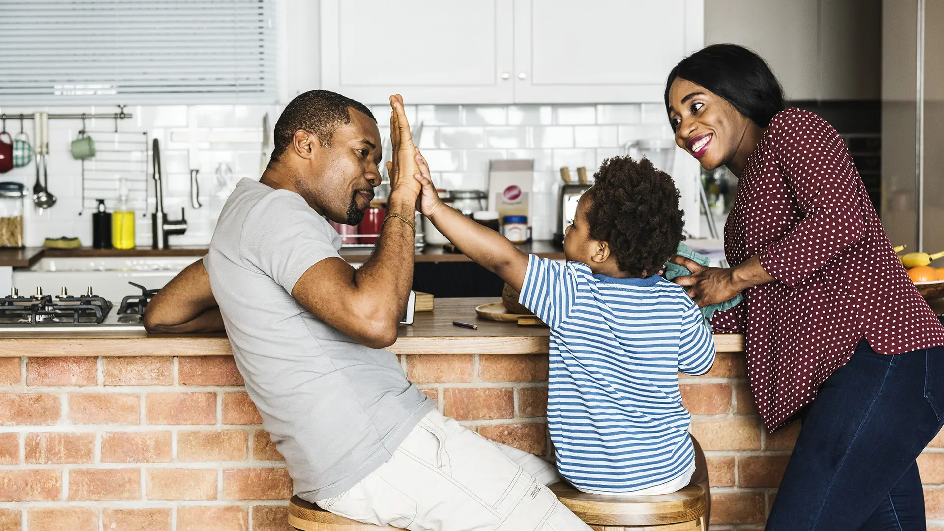 Family High Fiving In Kitchen